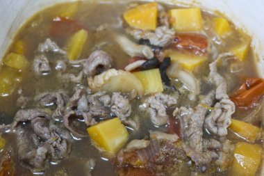 Ev yapımı Çin güvecini, tatlı patates, domates, balkabağı ve beyaz tencerede çorba ve sosla kaplayın.