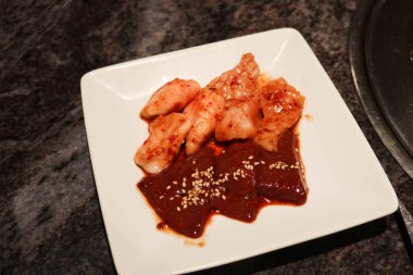 Izgaraya hazır beyaz tabakta pişmemiş çiğ sığır eti bağırsakları ve ciğer yakın çekim (Japon yakiniku)