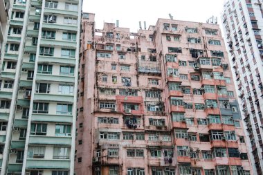 Quarry Bay, Hong Kong - 26 Aralık 2024: Yick Cheong Binası için pembe eski apartman binası ya da gündüz pencereli ve ön cepheli Canavar Binası olarak da bilinir.