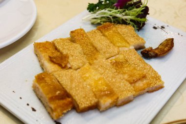 Çin usulü çıtır kemiksiz tavuk ve üstü susamlı karides dolması ve parçalara ayrılması. 