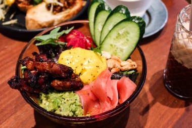 Kızarmış tavuk ve cevizli salata, turşulu zencefil, salatalık, şekerli domates, yeşil sebze, ezilmiş avokado ve şeffaf bir kasede zerdeçal tahini.