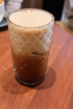 Şeffaf bardakta buzlu sütlü sütlü sütlü sütlü çay. Süt üstte, kahve altta iki katmanlı.