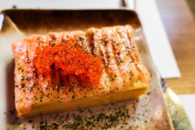 close up of rectangular Japanese rolled egg omelette (Tamagoyaki) with salmon roe (ikura) and seaweed powder clipart