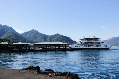 Miyajima Matsudai Kisen Feribot Terminali, Hiroshima, Japon- 9 Aralık 2024: Mavi gökyüzü ve deniz ile gündüz deniz kenarında feribotlu iskele.