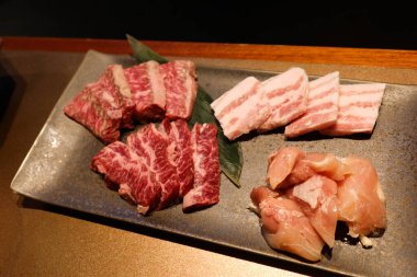 Pişmemiş çiğ Japon mermer wagyu bifteğini farklı dilimlere ayırın. Buna ızgara yakiniku malzemesi olarak hazırlanmış fileto, kaburga ve fileto da dahil.