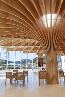 Otake, Hiroşima, Japonya - 12 Aralık 2024: SIMOSE (Simose Sanat Müzesi) kavisli ahşap ahşap mimari tasarımı, beyaz resepsiyon kasiyeri masası ve Shigeru Ban tarafından tasarlanmış kafe tablosu
