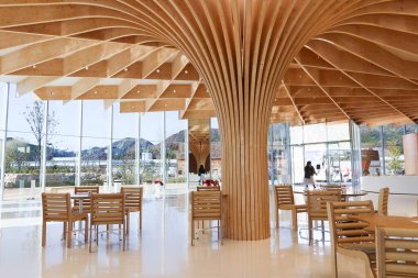 Otake, Hiroşima, Japonya - 12 Aralık 2024: SIMOSE (Simose Sanat Müzesi) kavisli ahşap ahşap mimari tasarımı, beyaz resepsiyon kasiyeri masası ve Shigeru Ban tarafından tasarlanmış kafe tablosu
