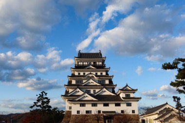 Fukuyama Şatosu, Fukuyama, Hiroşima, Japonya - 10 Aralık 2024: Kale, savaş ve gündüz vakti Japon kalesi mavi gökyüzü ve parktaki kum sahası kopyalanmış kopyasıyla korunma