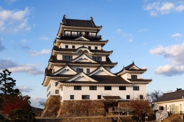Fukuyama Şatosu, Fukuyama, Hiroşima, Japonya - 10 Aralık 2024: Kale, savaş ve gündüz vakti Japon kalesi mavi gökyüzü ve parktaki kum sahası kopyalanmış kopyasıyla korunma