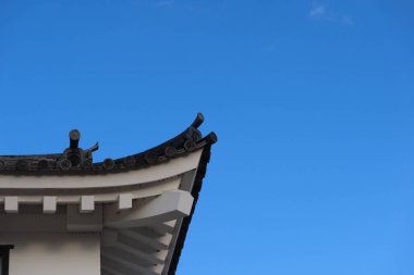 Fukuyama Şatosu, Fukuyama, Hiroşima, Japonya - 10 Aralık 2024: Mavi gökyüzü ve fotokopi uzayı olan bir Japon asya çatısının kıvrımlı köşesine yakın çekim