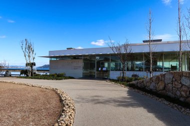 Otake, Hiroşima, Japonya - 12 Aralık 2024: SIMOSE (Simose Sanat Müzesi) Fransız restoranının gündüz mavi gökyüzü ve yolu üzerindeki dış cam binası 