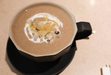 Mantar kremalı çorbayı bardakta, üzerinde ekmek zarları olan bir kapta kapat.