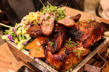 Peru usulü ızgara et, sığır filetosu, fırında tatlı patates, salata, tavuk, sucuk ve fırında sosis.