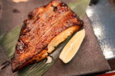 close up of Japanese grilled Saikyo miso Snow black cod Fish on a leaf and serving plate clipart