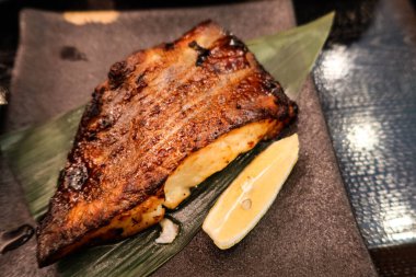 Japon ızgara Saikyo miso 'ya yakın. Kar siyah morina balığı. Yaprakta balık ve servis tabağı.