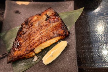 Japon ızgara Saikyo miso 'ya yakın. Kar siyah morina balığı. Yaprakta balık ve servis tabağı.