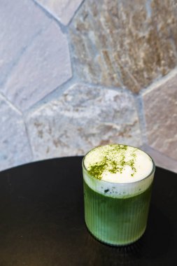 Soğuk buzlu sütlü yeşil çay sütlü sütlü sütlü sütlü sütlü sütlü sütlü sütlü sütlü sütlü sütlü sütlü sütlü sütlü sütlü sütlü sütlü sütlü sütlü sütlü sütlü sütlü sütlü sütlü sütlü sütlü sütlü kahve tozu siyah bir masada şeffaf bir bardakta.