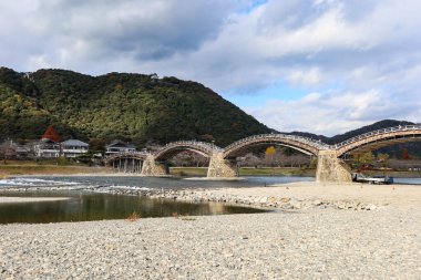 Kintaikyo Köprüsü, İwakuni, Yamaguchi, Japonya - 12 Aralık 2024: Gündüz vakti nehir kenarındaki kemer köprüsü