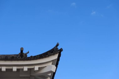 Fukuyama Şatosu, Fukuyama, Hiroşima, Japonya - 10 Aralık 2024: Mavi gökyüzü ve fotokopi uzayı olan bir Japon asya çatısının kıvrımlı köşesine yakın çekim