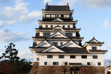 Fukuyama Castle, Fukuyama, Hiroshima, Japan- 10 Dec 2024: Japanese castle for fortress, war and protection in daytime with blue sky at sunset with park sand ground with copyspace clipart