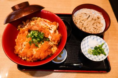 Japon yemek takımını bol yağda kızartılmış domuz pirzolası pilav (Katsudon) ve soba eriştesi ile kapatın. 
