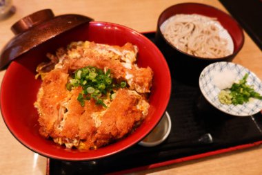 Japon yemek takımını bol yağda kızartılmış domuz pirzolası pilav (Katsudon) ve soba eriştesi ile kapatın. 