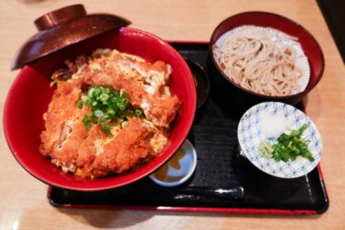 Japon yemek takımını bol yağda kızartılmış domuz pirzolası pilav (Katsudon) ve soba eriştesi ile kapatın. 
