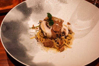 İtalyan taglioni spagettisine yakın beyaz trüf mantarlı makarna ve beyaz gri tabakta fotokopi alanı olan mantar.