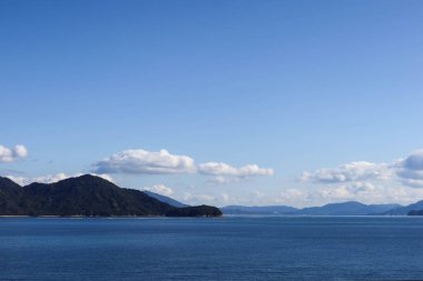 Dağ ve mavi gökyüzü beyaz bulutlu mavi okyanus. Duvar kağıdı için alanı kopyala