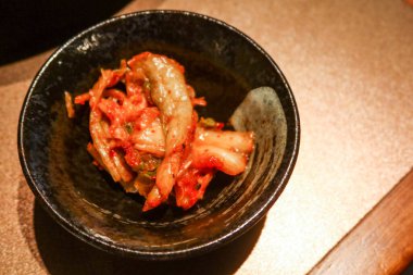 Koreli başlangıç oyuncusu Kimchi 'yi fotokopi alanı olan siyah bir kasede kapat.