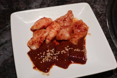 Beyaz bir palette ızgara yapmak için kanlı sığır eti bağırsağı ve sığır ciğeri malzemesi olarak kapatılıyor.