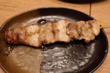 Japon Yakitori domuz şiş yakın bir tabakta bambu çubuk ile