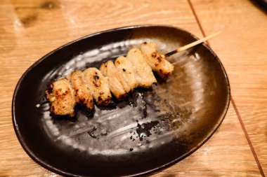 close up of Japanese yakirori skewer, grilled chicken meat on a bamboo stick with copy space