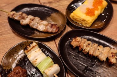 Tavuk eti, domuz eti, yumurta (tamago) ve Galler soğanı dahil olmak üzere dört Japon şiş tabağını kapatın.