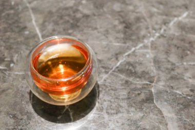 Fotokopi alanı olan mermer bir masanın üzerindeki bir bardakta sıcak çayı kapat.