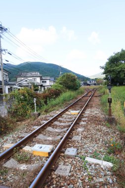 Yufuin, Yufu, Kitakyushu, Japonya- 6 Kasım 2024: Yufuin İstasyonu 'ndaki demiryolu geçidi. Yan taraftaki evler ve ağaçlar..