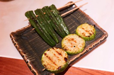 Japon ızgara bamya ve kabak şişini fotokopi alanı ile aynı tabakta kapat.
