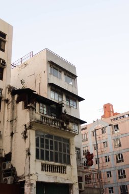 Kowloon City, Hong Kong - 12 Ocak 2025: Kopya uzayı ile günbatımında alçak açılı eski bir apartmanın dış yüzeyi. 