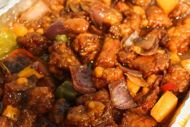 Çin usulü tatlı ve ekşi kızarmış domuz eti, biber ve ananaslı alüminyum folyo tepsisi.