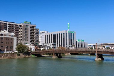 Kokura, Kitakyushu, Japonya - 3 Kasım 2024: Mavi gökyüzünde binaları olan Tokiwa Köprüsü Murasaki Nehri boyunca güzel hava koşulları