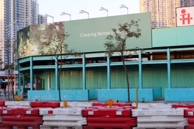 Kowloon City, Hong Kong - 12 Ocak 2025: Mülkü daha iyi tanıtan bir inşaat alanı. Önde kırmızı ve beyaz bariyerler