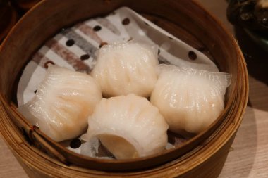 Buharda pişirilmiş dört Kanada karidesli böreğini bambu buharlı tencerede yakın çekim yapın.