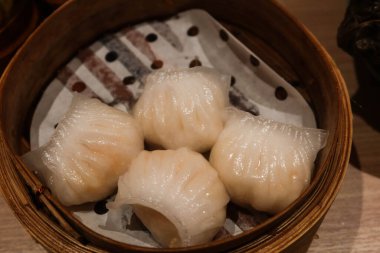 Buharda pişirilmiş dört Kanada karidesli böreğini bambu buharlı tencerede yakın çekim yapın.