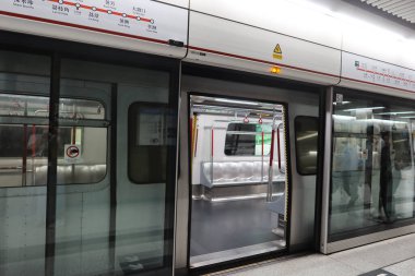 Merkez, Hong Kong - 25 Ocak 2025: MTR Tsuen Wan Hattı Platformu kapısı açık, bagajlı yolcular içeride