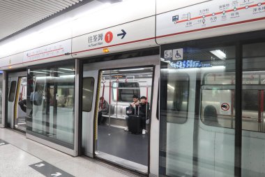 Merkez, Hong Kong - 25 Ocak 2025: MTR Tsuen Wan Hattı Platformu kapısı açık, bagajlı yolcular içeride