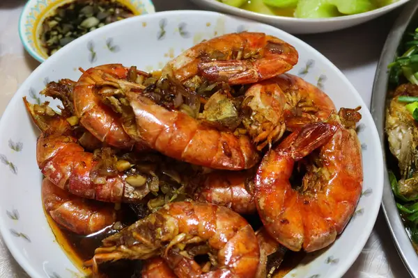 Kanton soya sosuna yakın turuncu kırmızı renkte kızarmış karides, sarımsak ve diğer baharatları bir tabakta karıştırın. 