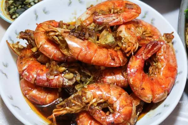 Kanton soya sosuna yakın turuncu kırmızı renkte kızarmış karides, sarımsak ve diğer baharatları bir tabakta karıştırın. 