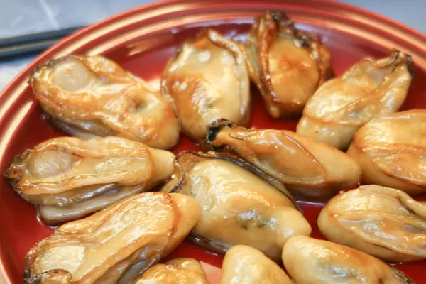 Çin Yeni Yıl Yemeği 'ne yakın yarı kurutulmuş, ballı istiridye soslu kırmızı tabakta iyi şans getirmesi için.