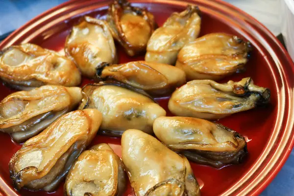 Çin Yeni Yıl Yemeği 'ne yakın yarı kurutulmuş, ballı istiridye soslu kırmızı tabakta iyi şans getirmesi için.