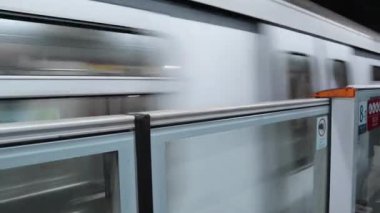 Tsuen Wan, Hong Kong - 4 Nisan 2025: MTR treni yolcu kuyruğu ve kapı açıkken platforma yaklaşıyor